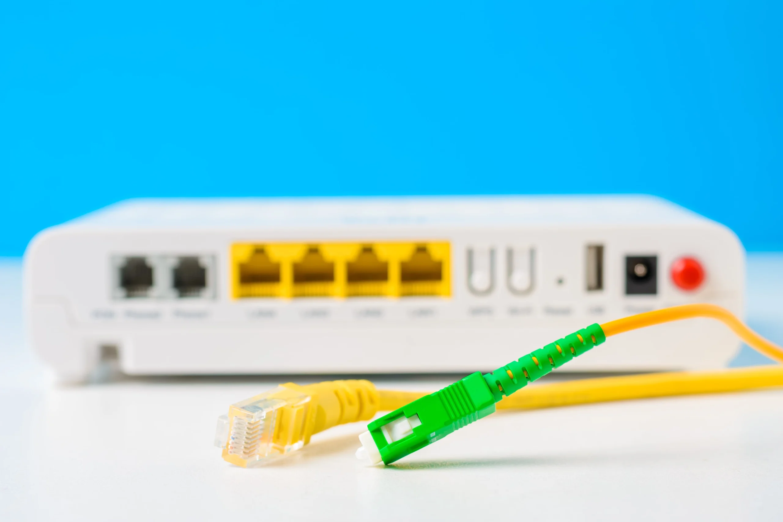 Fiber optical and network cables with internet wireless router on a blue background