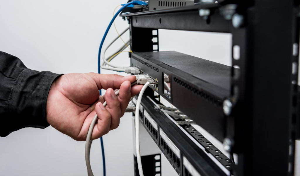 Technician Connecting Network Cables To Switches. Connecting Cables In Server Cabinet.